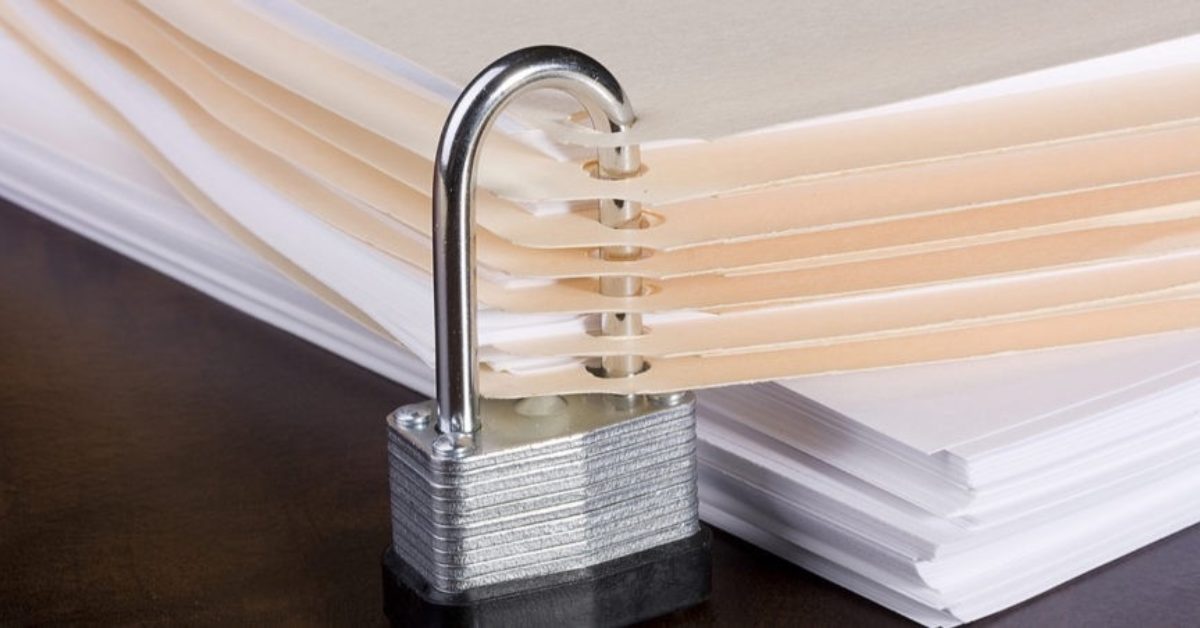 A stack of folder and papers with a padlock going through it