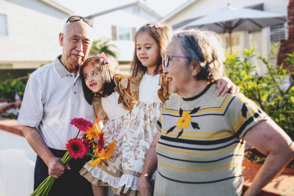 Image of grandparents with grandkids smiling and hugging